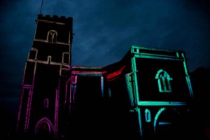 Holy Trinity Church with projections on it - so the lines of the edges of the building are lit up with neon colours